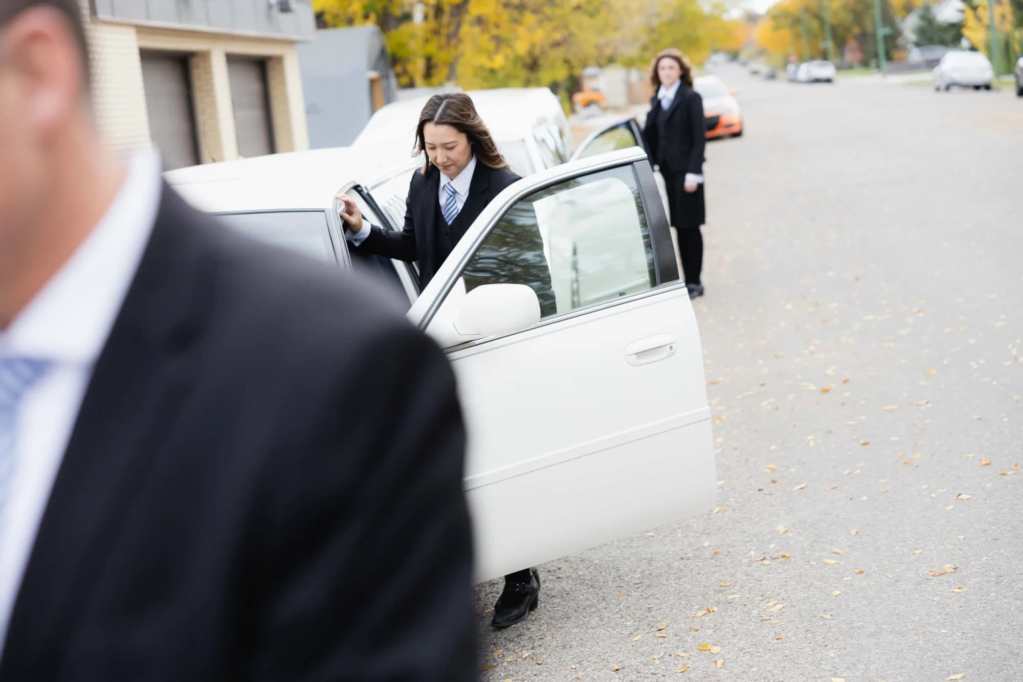 A Generations funeral director helping a mourner from the limousine.